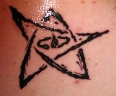 a star tattoo on the back of a woman's upper arm, with black ink