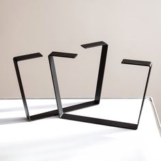 three black metal objects sitting on top of a white table