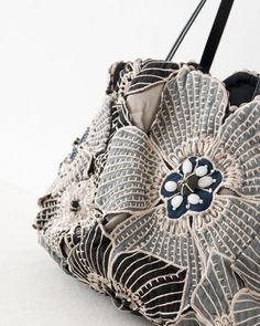 a black and white purse with flowers on the front, sitting against a white background