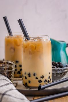 two glasses filled with iced coffee sitting on top of a table