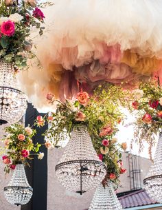 several chandeliers with flowers hanging from them