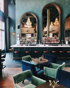 an empty bar with blue chairs and wooden tables