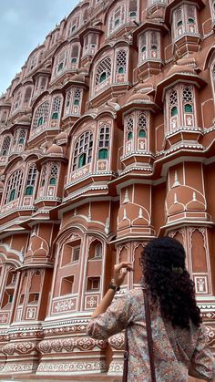 a woman standing in front of a tall building