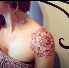 a woman with a tattoo on her shoulder has a large flower in the middle of her arm