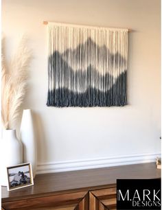 the wall hanging is decorated with black and white yarn