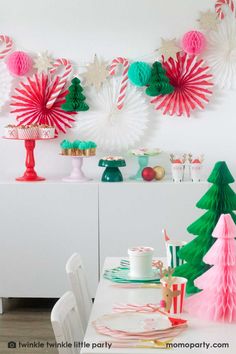 the table is set for christmas dinner with paper trees and candy canes on it