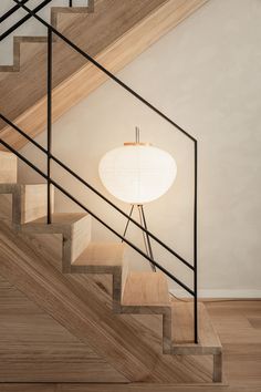 a lamp sitting on top of a wooden stair case next to a bannister