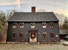 a black house with wreaths on the front door