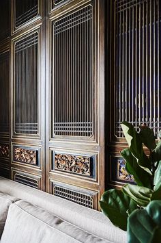 a living room filled with lots of furniture and walls covered in metal screens on top of wooden