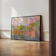 an abstract painting on the wall next to a wooden floor in a room with white walls