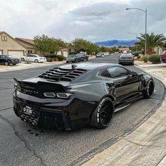 a black sports car is parked on the street