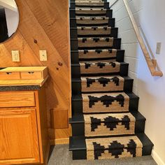 the stairs are decorated with black and beige rugs