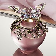 a pink vase with a butterfly decoration on it