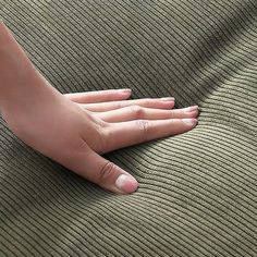 a person's hand resting on the back of a couch cushion, close up