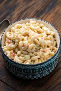 a bowl filled with macaroni and cheese on top of a wooden table