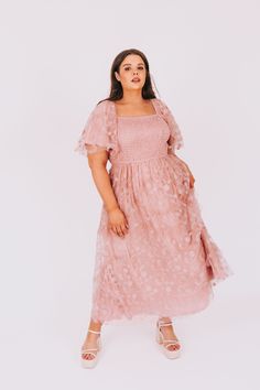 Get ready to turn heads with the PLUS SIZE - Take Me To The Ball Dress. This stunning dress features embroidered floral mesh, adding a touch of elegance to your look. The smocked top provides a comfortable and flattering fit, while the flutter sleeves add a flirty and feminine touch. Perfect for any special occasion, this dress will be sure to make you feel like the Belle of the ball! Details Embroidered floral mesh Smocked top Flutter sleeves Sizing Approximate measurements: SIZE LENGTH BUST Sm Pink Smocked Dress With Floral Embroidery For Summer, Spring Floral Embroidered Fitted Smocked Dress, Nursing Friendly Dress, Plus Jumpsuit, Exclusive Dress, Smocked Top, Maternity Shops, Basic Dress, Tank Top Long Sleeve