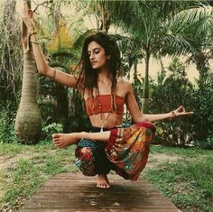 a woman is doing yoga on a wooden platform