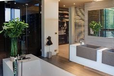 a bathroom with a tub, sink and large mirror on the wall next to it