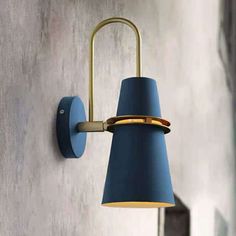 a wall light with a blue shade hanging from it's side on the wall