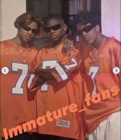 three men in orange jerseys standing next to each other