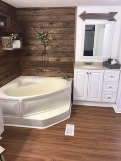 a white bath tub sitting on top of a wooden floor