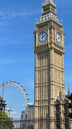 the big ben clock tower towering over the city of london with ferris wheel in the background