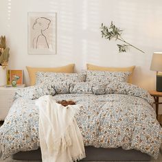 a bedroom with a bed covered in a floral comforter