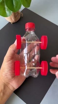 a hand holding a plastic bottle with toothpicks in it