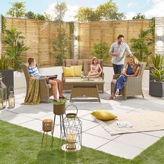 a group of people sitting on top of a patio next to a wooden privacy fence