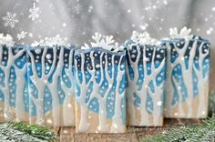 four blue and white candles sitting on top of a table covered in snowflakes