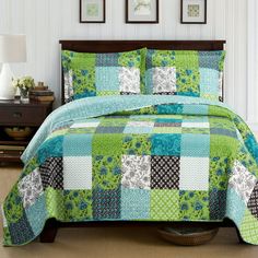 a bed with green and blue bedspread in a room