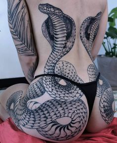 the back of a woman's stomach with black and white tattoos on her body