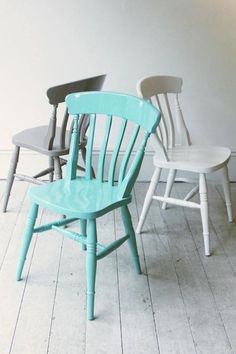 four chairs are lined up on the floor in front of a white wall and wooden floors