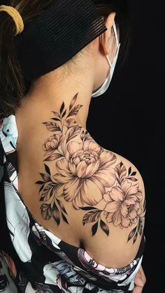 the back of a woman's shoulder with flowers on it