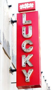 the lucky sign is hanging on the side of the building next to it's name