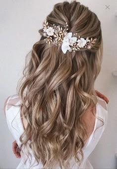 the back of a woman's head with long hair and flowers in her hair