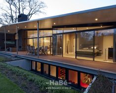 a modern house with glass walls and wooden decking