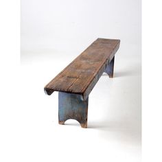 an old wooden bench sitting on top of a white floor