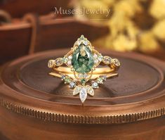 a close up of a ring on top of a wooden table with flowers in the background