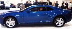 a blue sports car is on display at an auto show