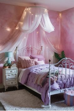 Whimsical bedroom with pink walls, white canopy bed, fairy lights, and vintage nightstand. Bedroom Earthy, Boho Girls Bedroom, Rattan Light Fixture