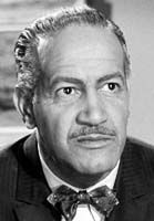 black and white photograph of a man in a suit with a bow tie looking at the camera