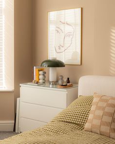 a bedroom with a bed, dresser and window