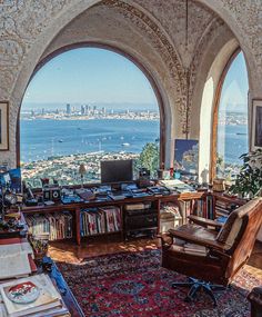 a living room filled with furniture and a large window overlooking the ocean in front of it