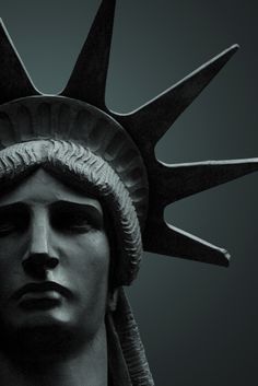 the statue of liberty's head is shown in black and white, against a dark background