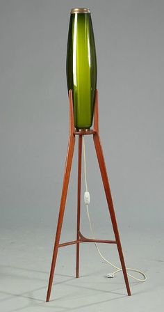 a green lamp sitting on top of a wooden stand