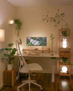 a white desk and chair in a room with wooden floors, plants on the wall