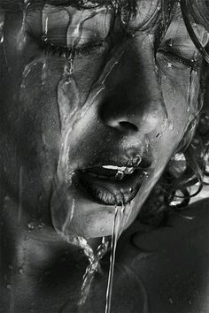 black and white photograph of a woman's face with water dripping from her mouth