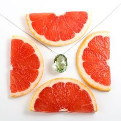 three slices of grapefruit, one green and the other cut in half on a white surface