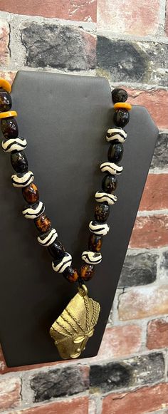 A breathe taking African necklace. The rich bone bead necklace make a strong Cultrual statement. The necklace is l7 inches in length.  No garment is complete with a statement piece. Don't delay order yours today. Black African Necklace, Artisan Necklace With Large Beads For Rituals, Spiritual Wooden Beaded Pendant Necklace, Artisan Necklaces With Large Beads For Healing, Spiritual Large Beads Necklace For Rituals, Spiritual Necklaces With Large Beads For Rituals, Adjustable Necklace With Large Beads For Rituals, Unique Hand-strung Necklaces For Rituals, Artisan Necklace With Wooden Beads For Meditation